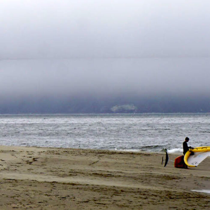 Fog covers the Golden Gate Bridge with two wingers in the foreground