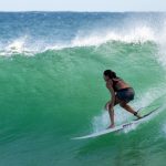 Woman surfing in board shorts
