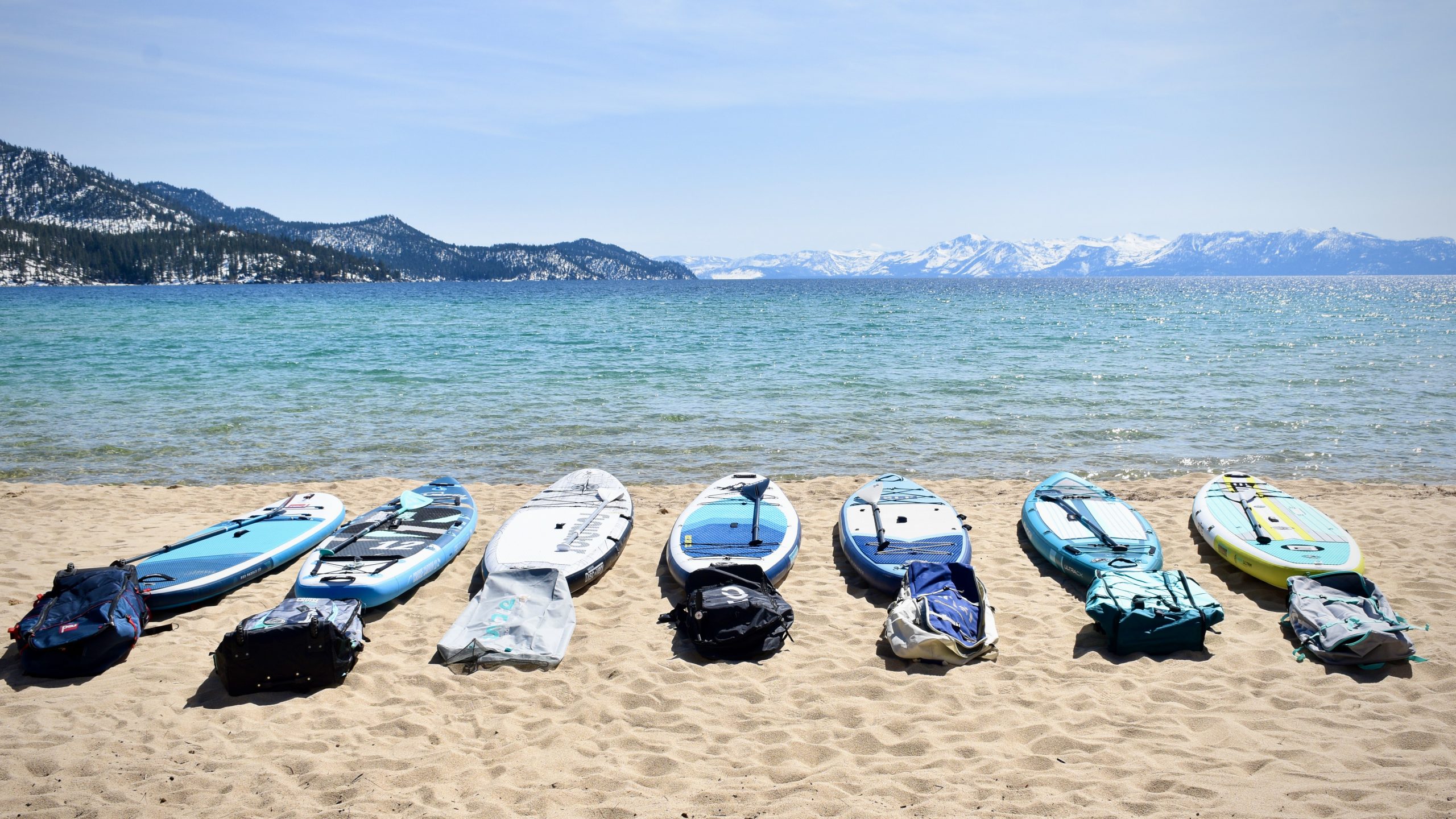 a lineup of seven of the best inflatable paddle boards being tested head-to-head at lake tahoe