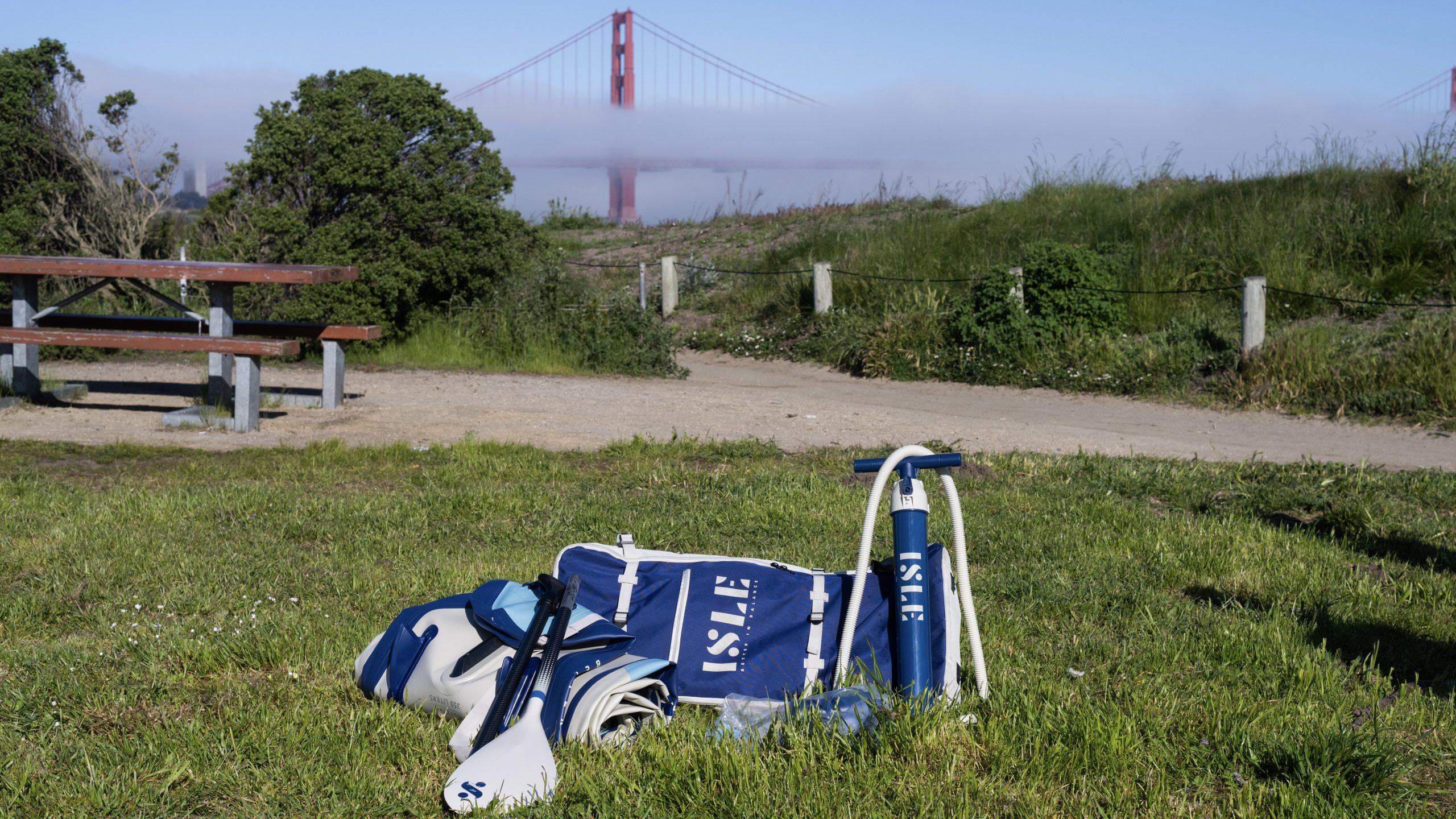 isle explorer inflatable paddle board and accessories on grass with golden gate bridge in background