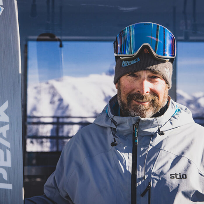 a man holding skis poses for a picture