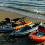 some of the kayaks we reviewed the best inflatable kayaks for 2023, shown here lined up on the beach.