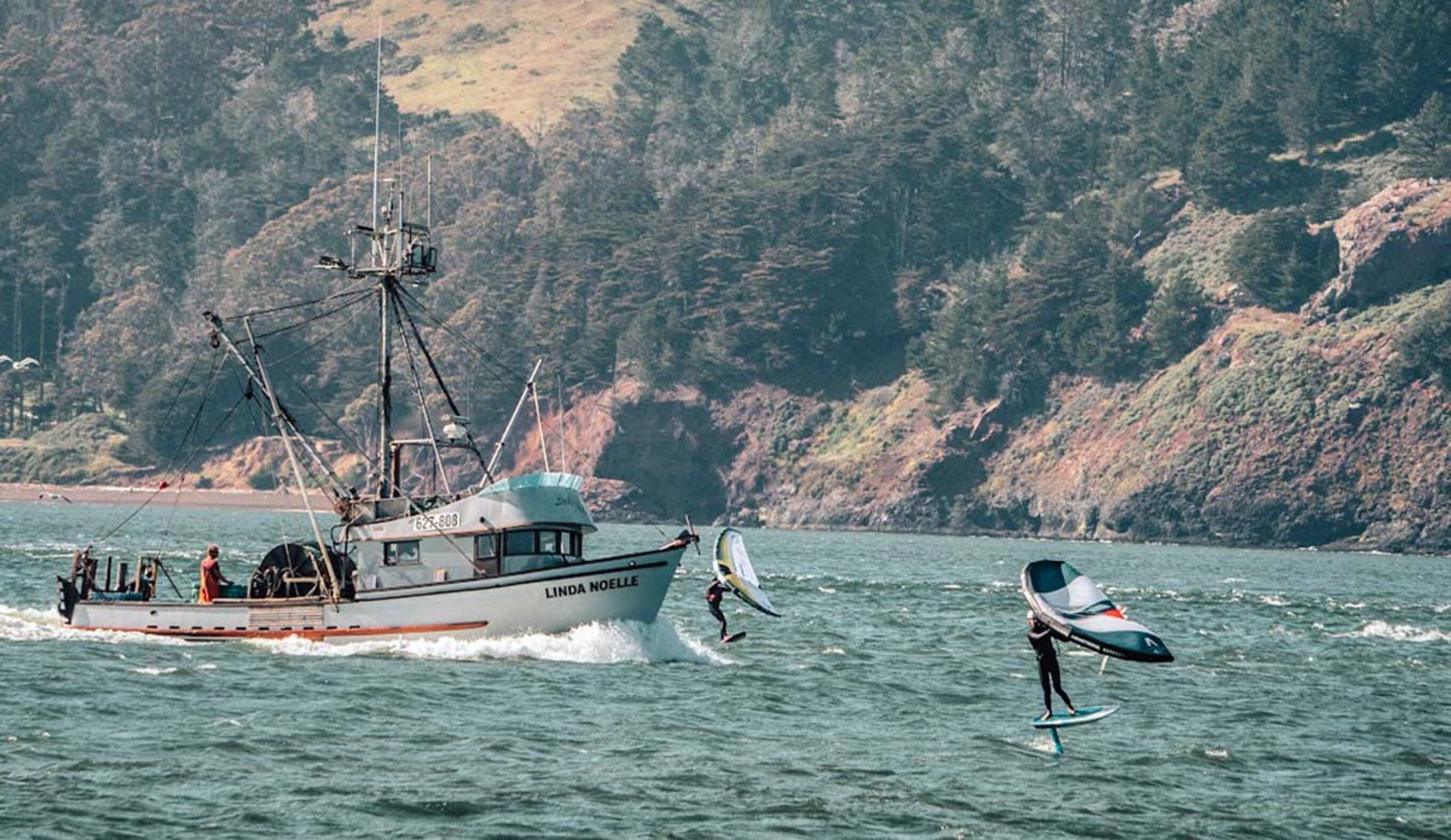 The Inertia's Will Sileo foiling in front of a boat