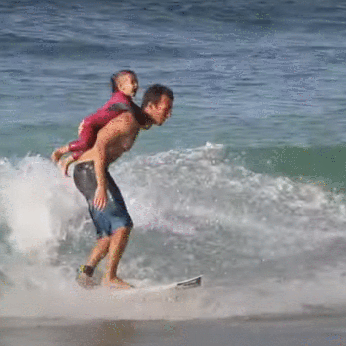 Cory Lopez surfing with his daughter Alana