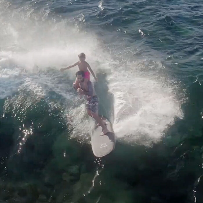Billy Kemper surfing with his son on Tavarua