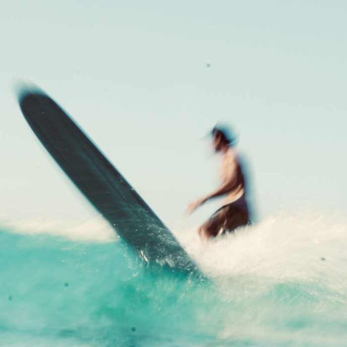 Longboard surfer finishes wave