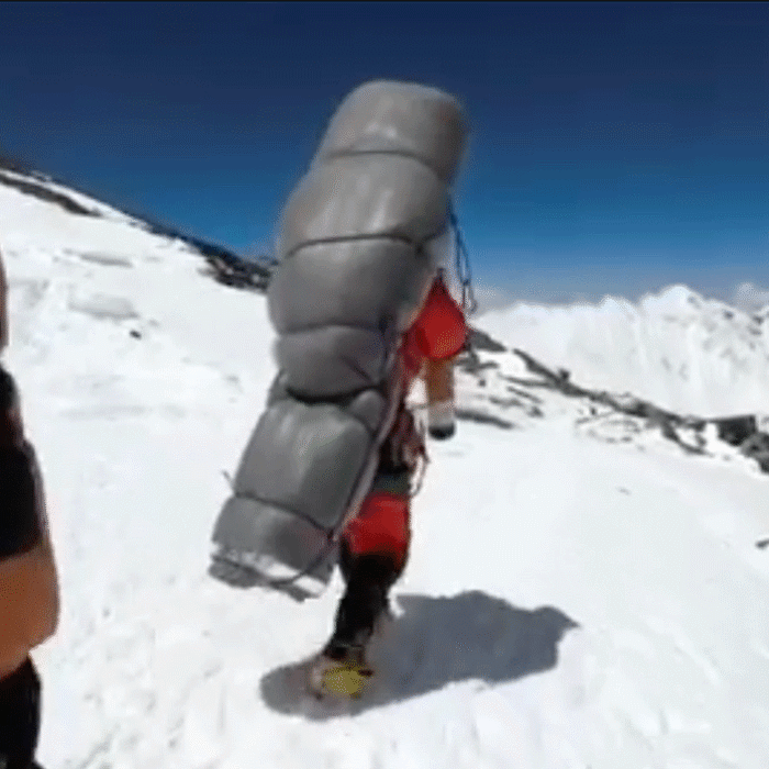 Gelje Sherpa carries a climber down Mt. Everest