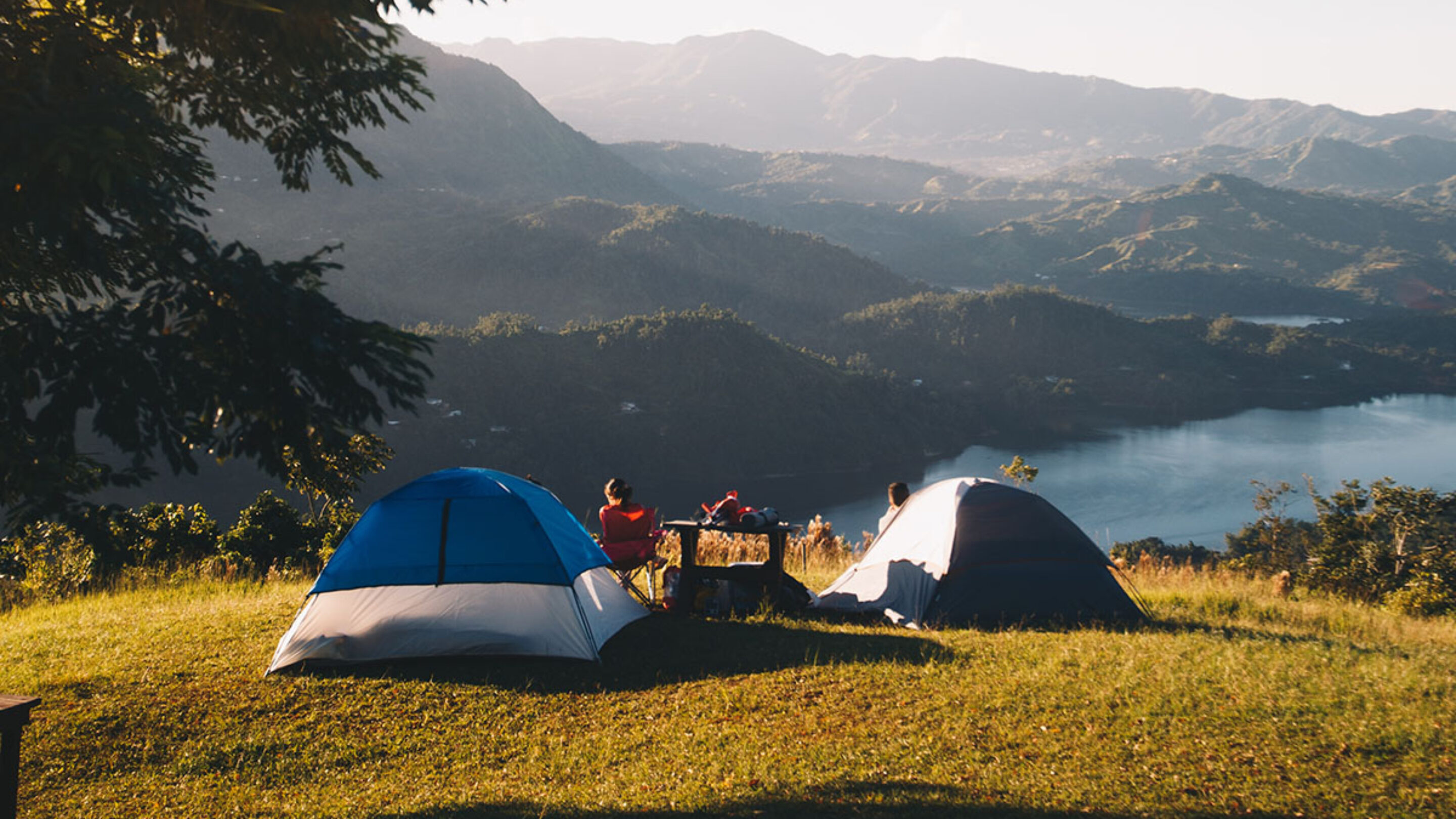 a campsite overlooking a mountain view and lake. photo by Victor Larracuente on Unsplash