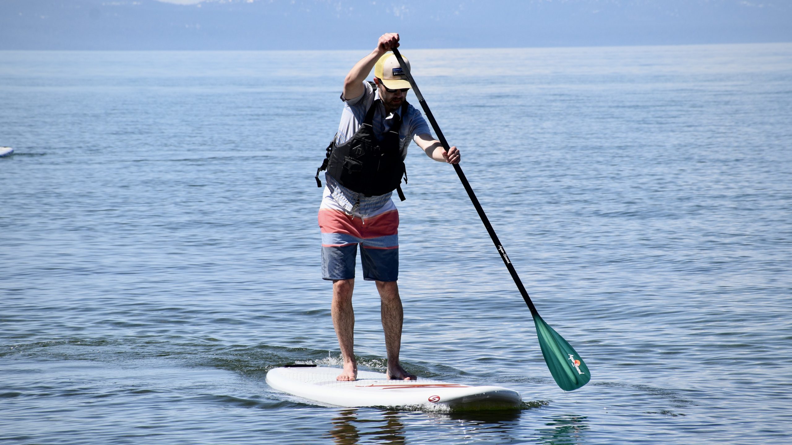 man paddle boarding on Lake Tahoe with the Aqua Bound Malta Fiberglass SUP paddle