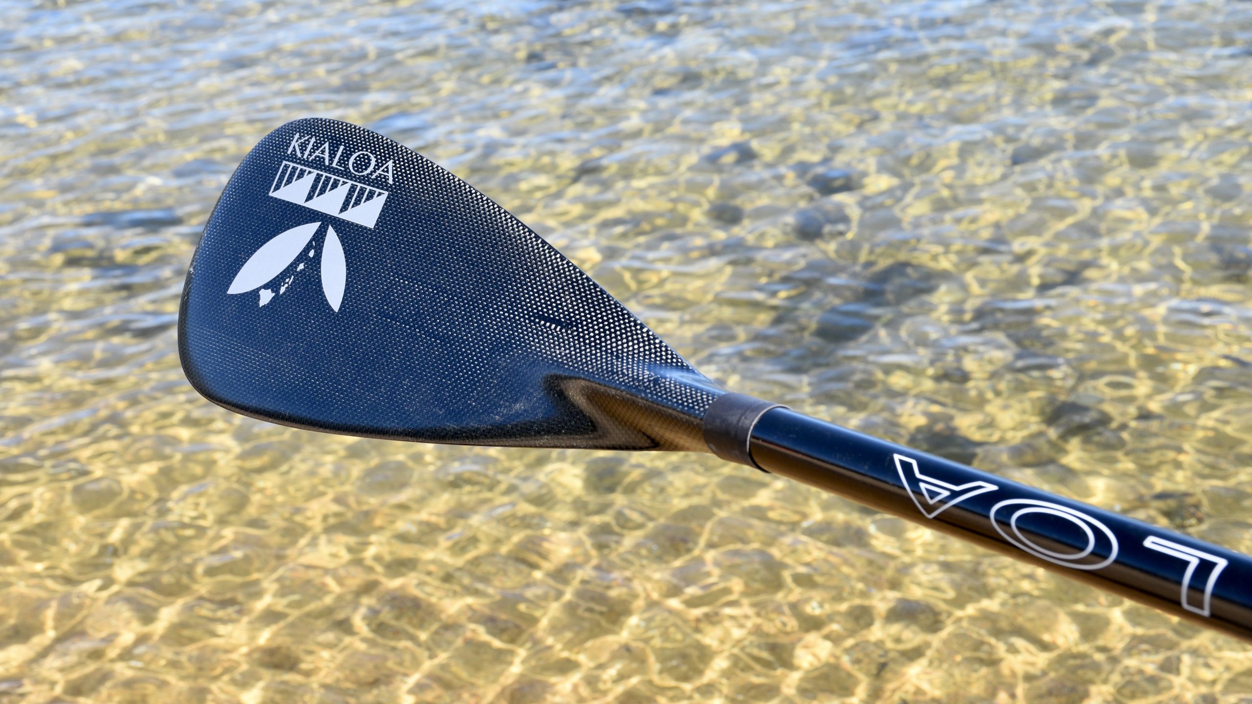 Showcasing the beautiful carbon fiber blade of the Kialoa Pipes II SUP paddle in front of Lake Tahoe