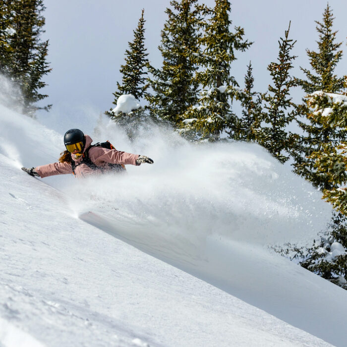 A woman rips powder snow.