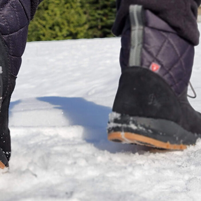 a shot of the vibram arctic grip outsoles on the danner cloud cap winter boots while walking in the snow