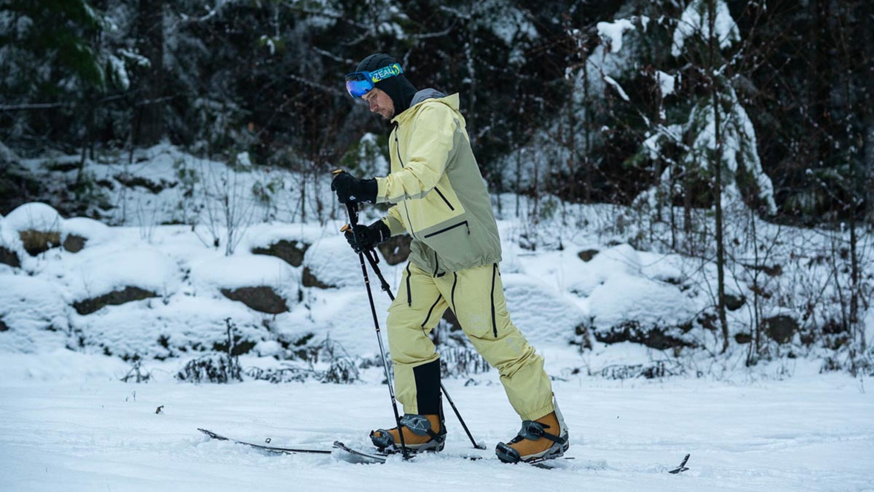 a splitboarder skinning up a trail using the Burton Kalausi jacket and pants
