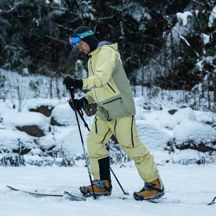 a splitboarder skinning up a trail using the Burton Kalausi jacket and pants