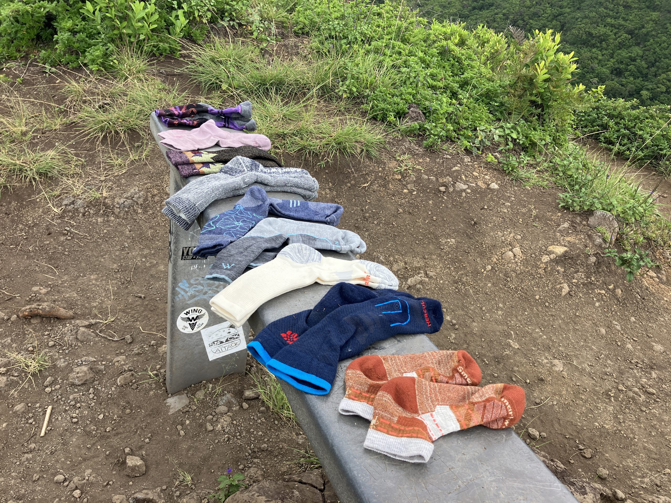 a row of hiking socks on a park bench