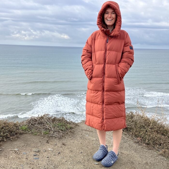 Women standing on the beach in a puffer jacket