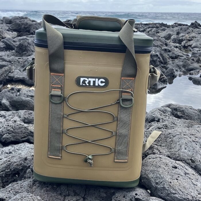 RTIC Backpack Cooler sitting on rocks at the beach