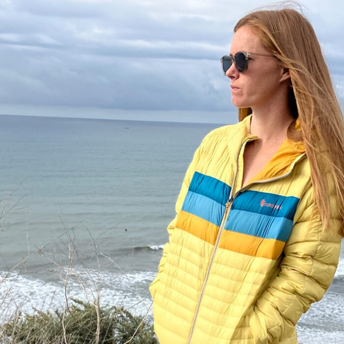 a woman wearing the Cotopaxi Fuego Down Hoodie