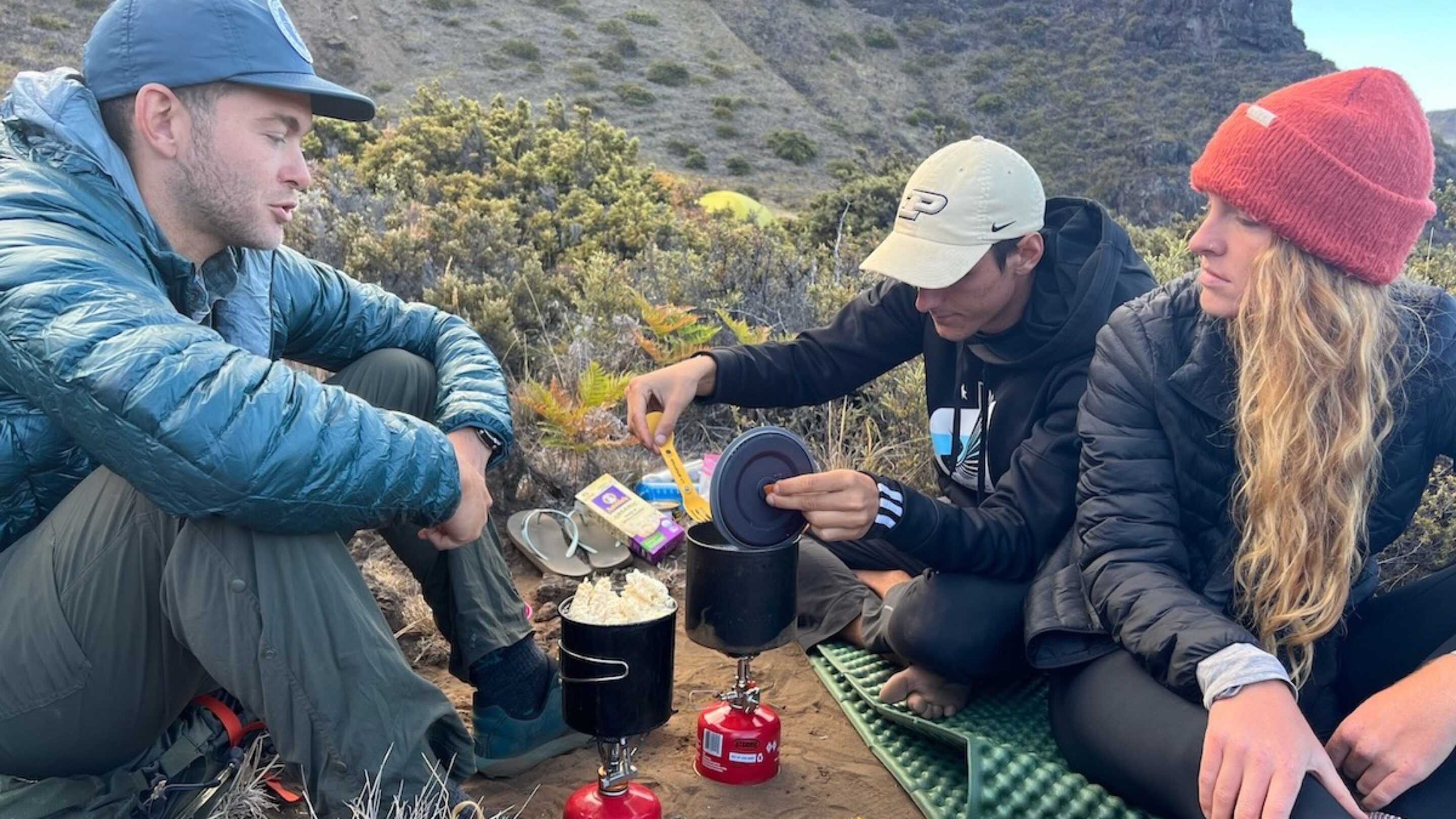 three friends making meals using backpacking stoves