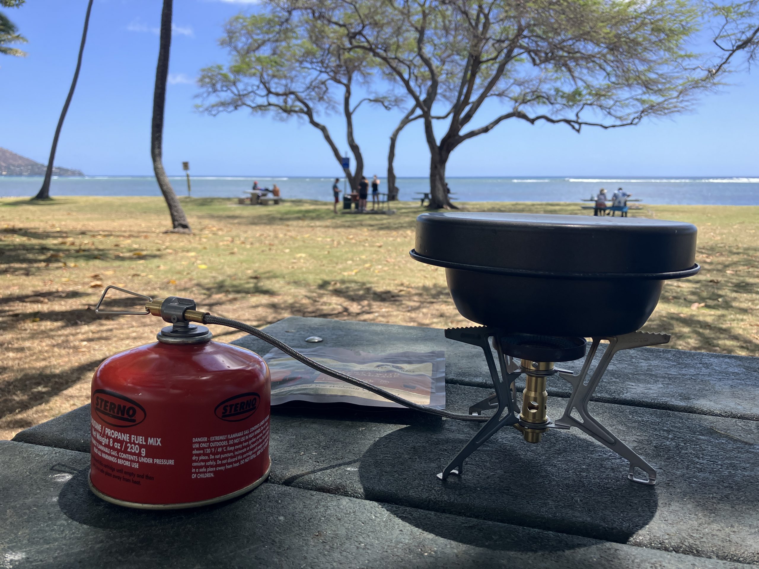 one of the backpacking stoves we tested for this guide sitting on a park bench at the beach