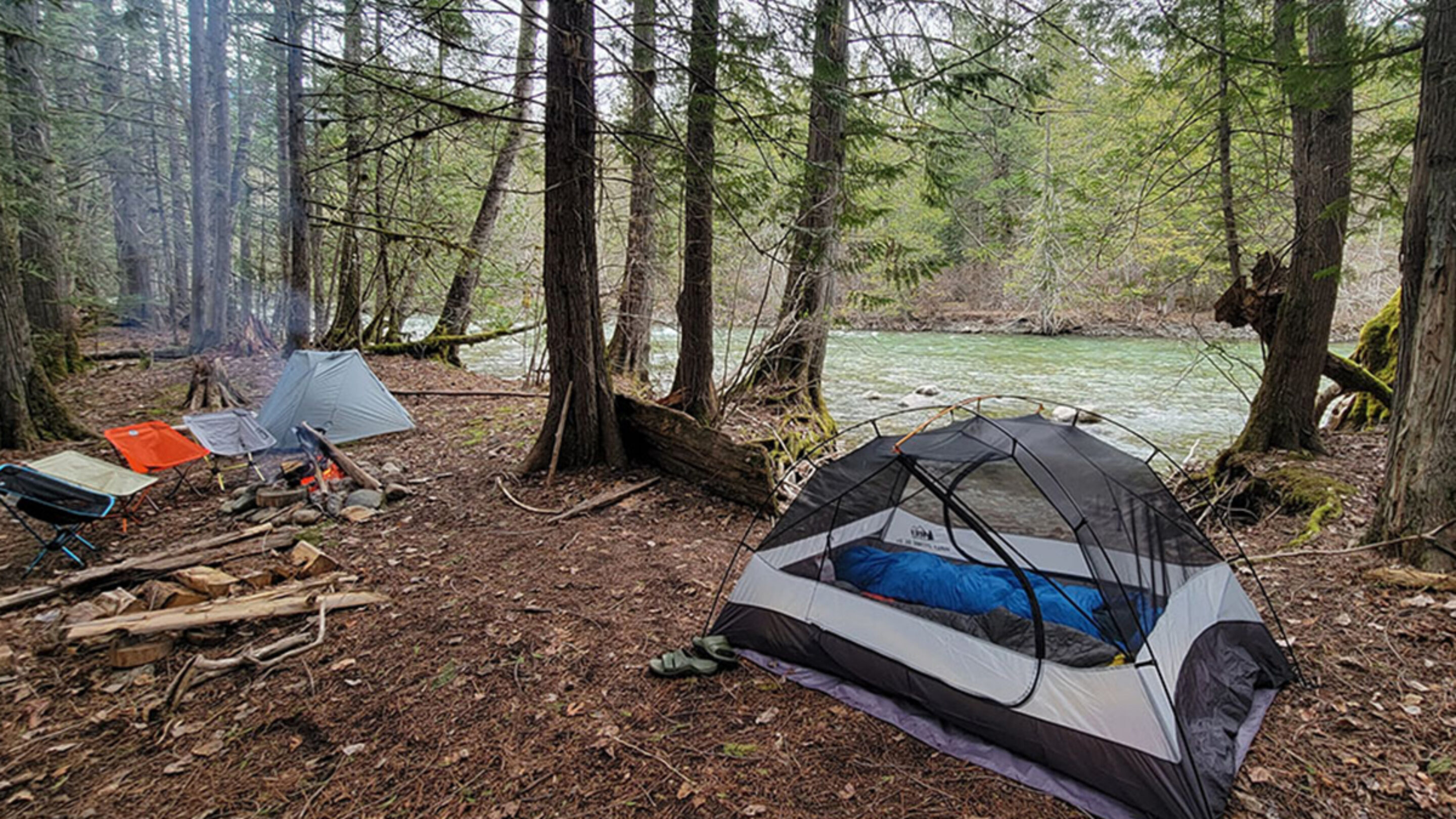 two backpacking tents next to a river