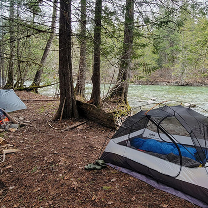 two backpacking tents next to a river