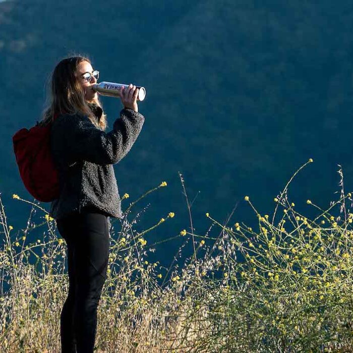 A female hiker drinking Arrowhead