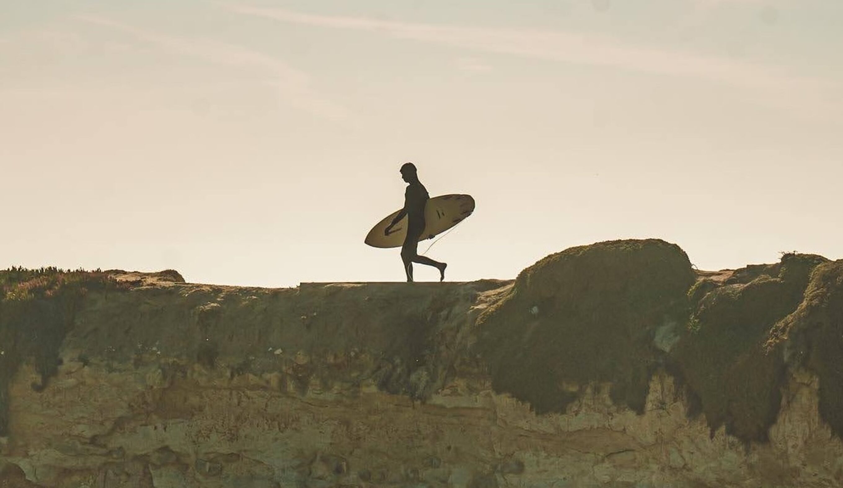 Man Walking with Surfboard on Cliff Steamer Lane