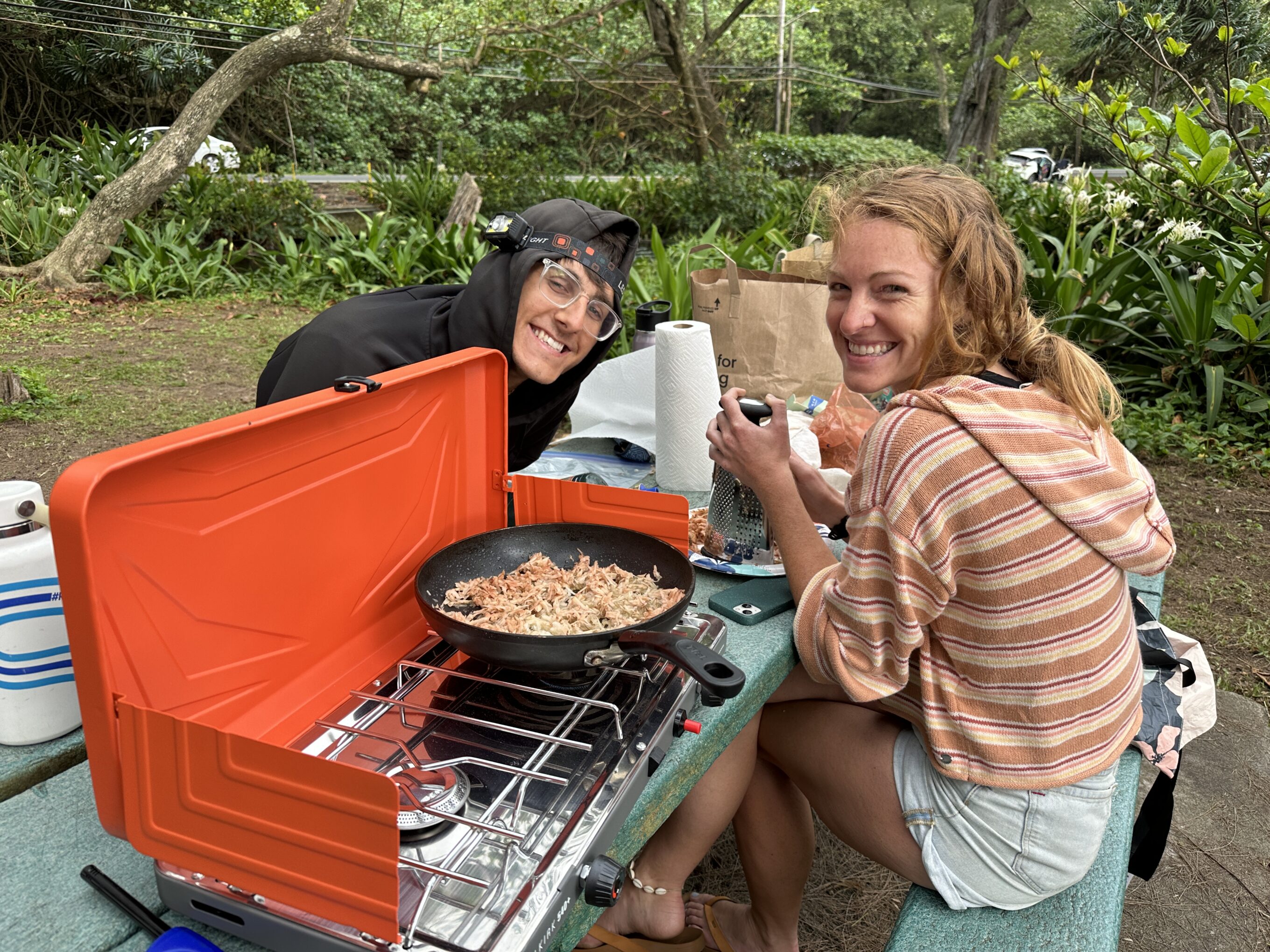friends using a camping stove to make breakfast