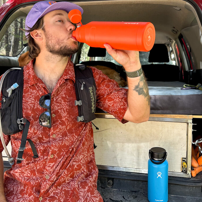 man drinking out of water bottle