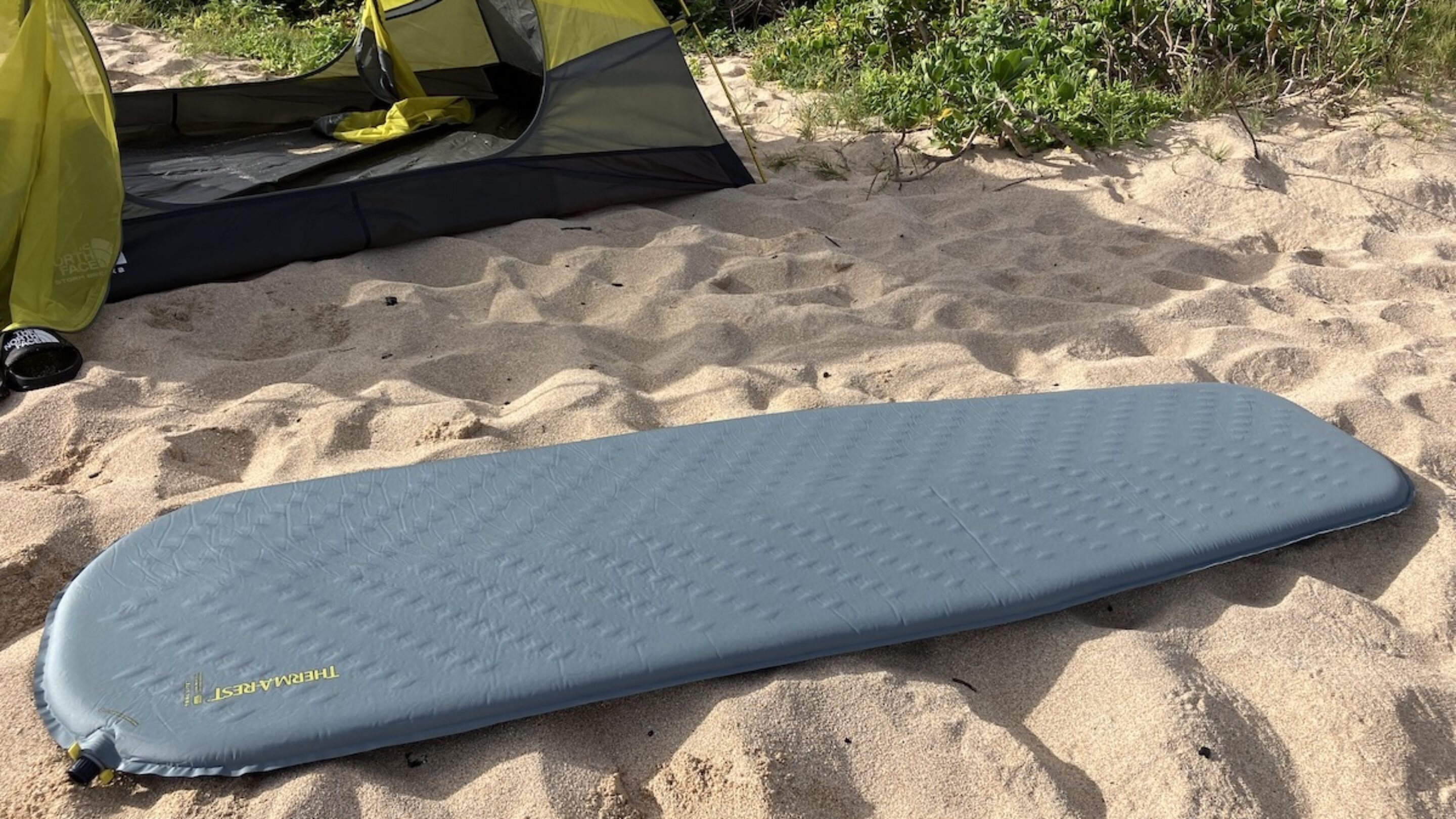 therm-a-rest sleeping pad on the sand in front of a tent