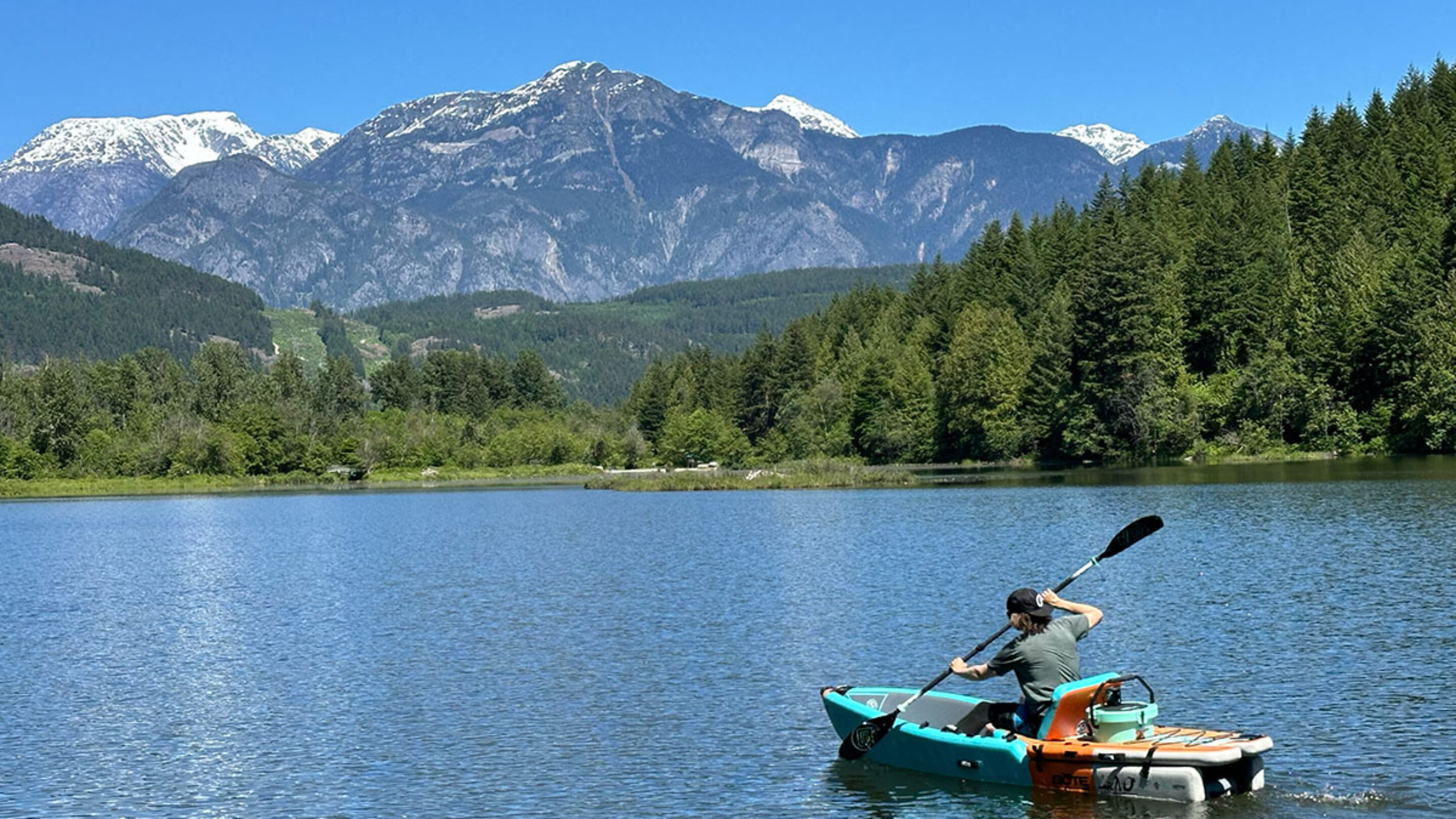 the bote aero lono kayak on a lake with a beautiful mountain backdrop