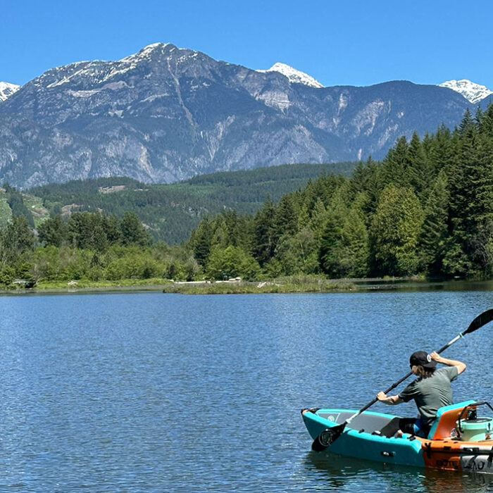 the bote aero lono kayak on a lake with a beautiful mountain backdrop