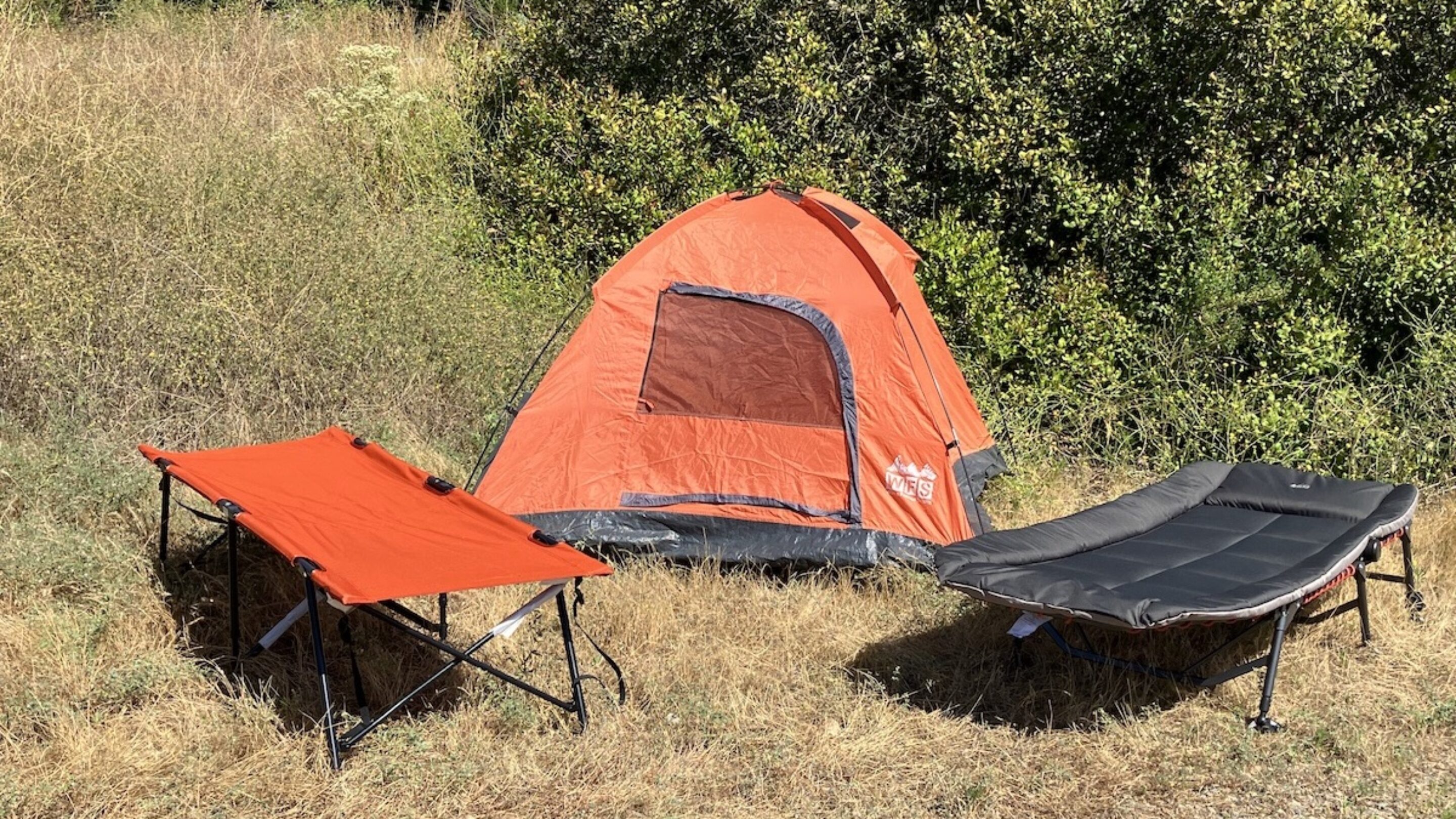 camping cots set up in front of a tent