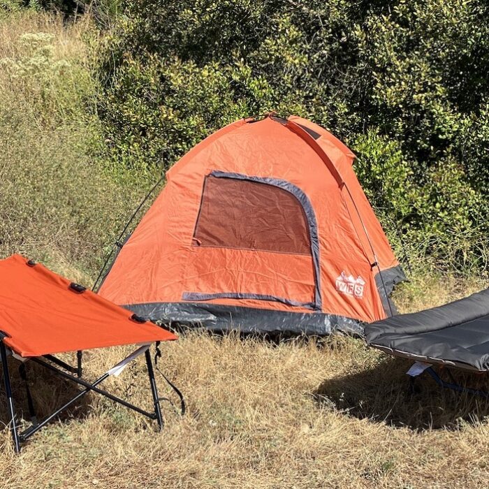 camping cots set up in front of a tent