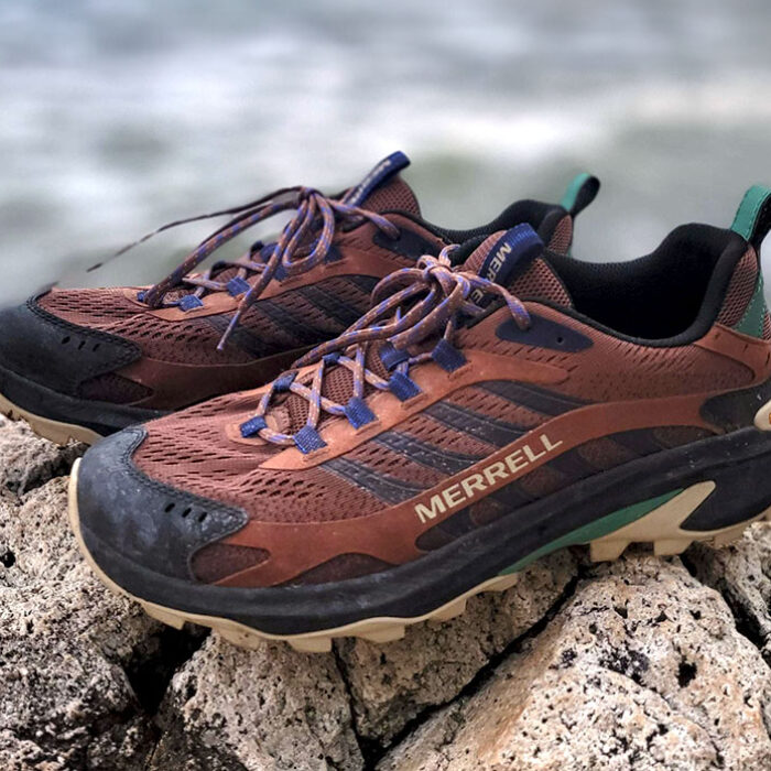 the Merrell Moab Speed 2 hiking shoes perched on a rock next to the ocean