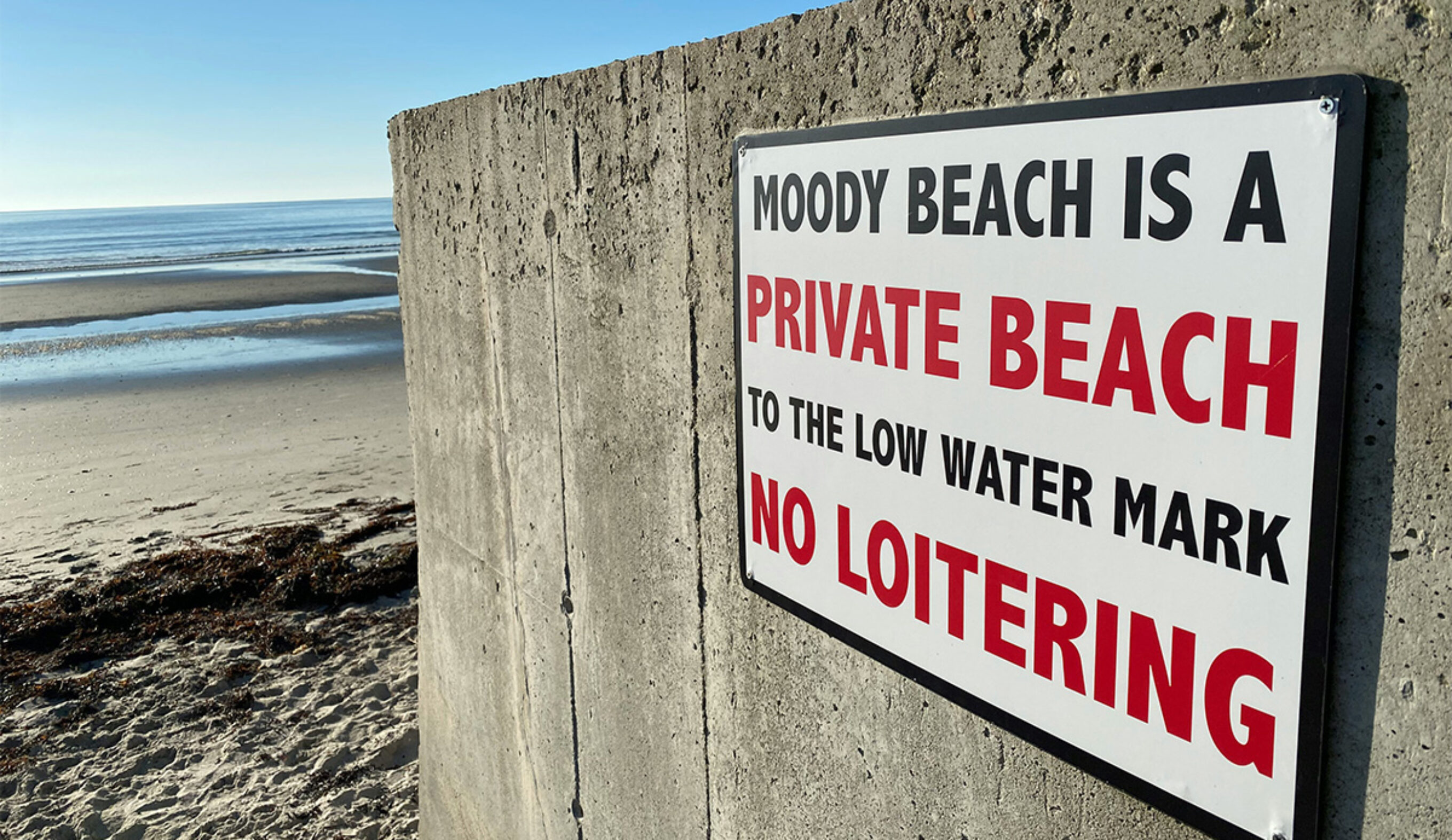 A sign warning the public away from Moody Beach in Wells, Maine. Photo: Jim Petkiewicz // Unsplash