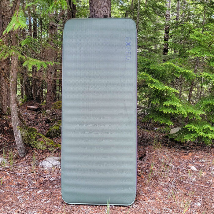 a picture of the exped megamat 10 next to a tree in the forest