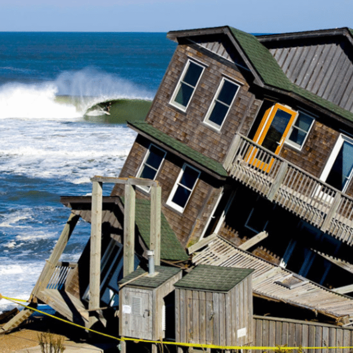 House falling into ocean with surfer getting barreled in background. Rodanthe, NC