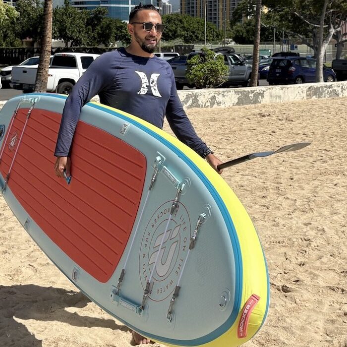 a man carrying a paddle board