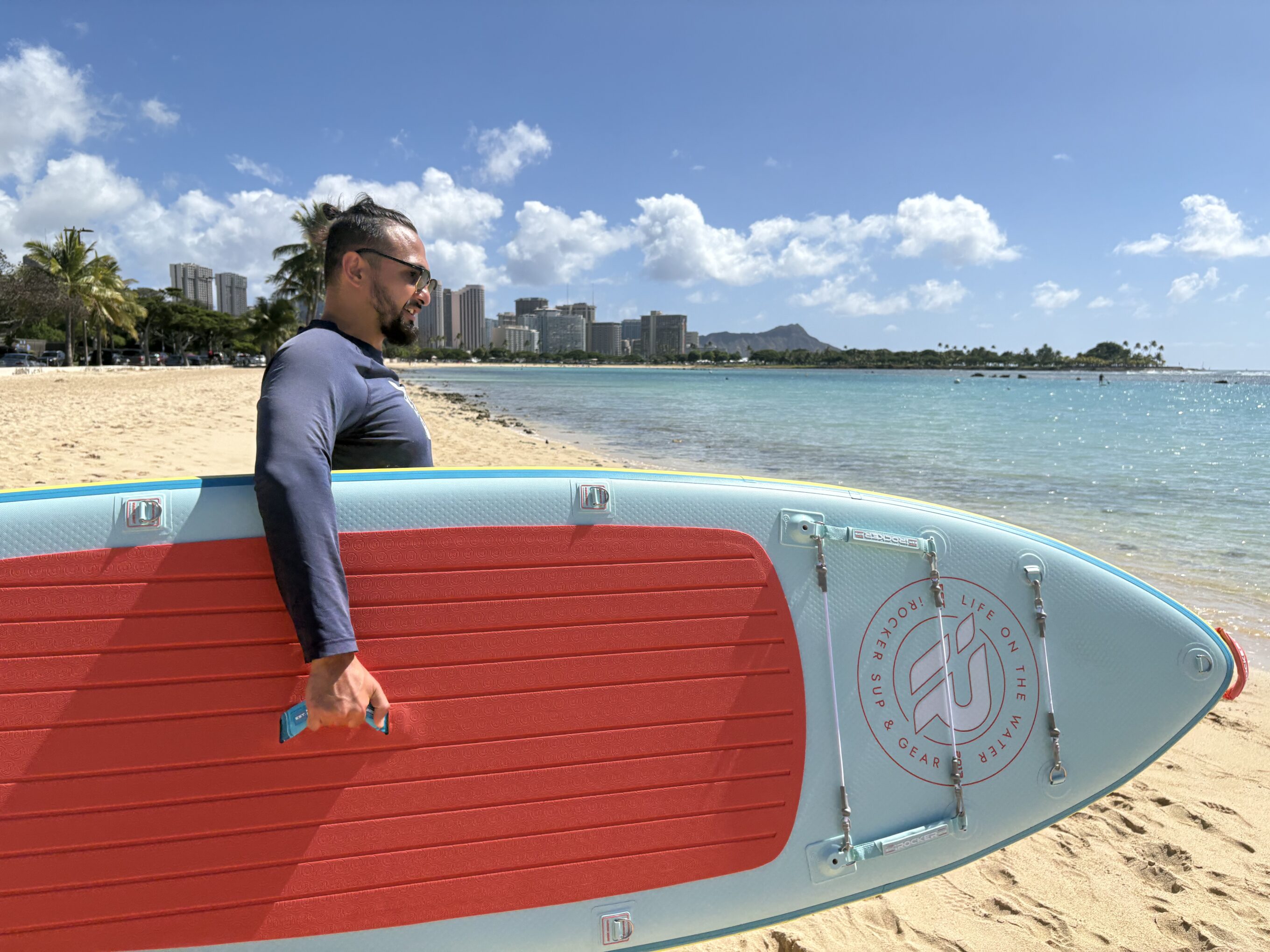 a man holding an iRocker Cruiser paddle board