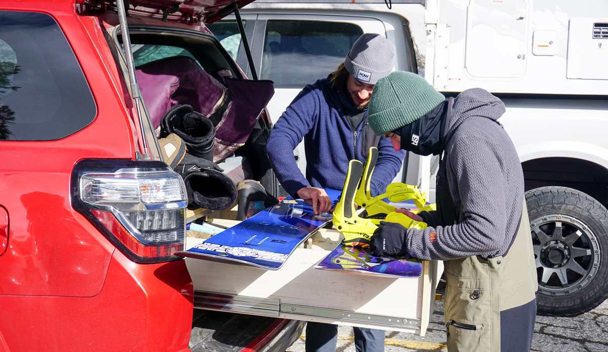 man putting bindings on snowboards
