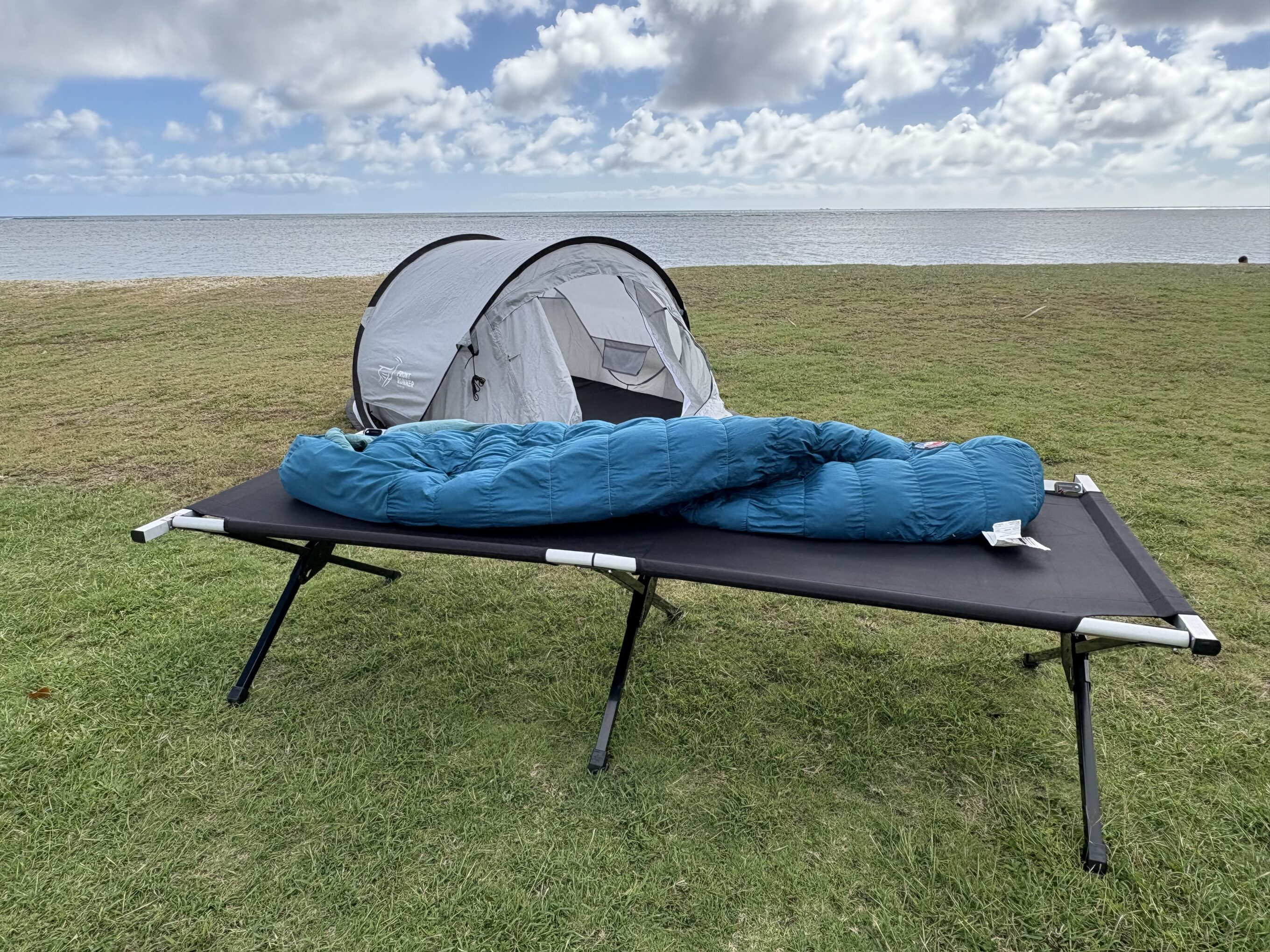 a camping cot in front of a tent