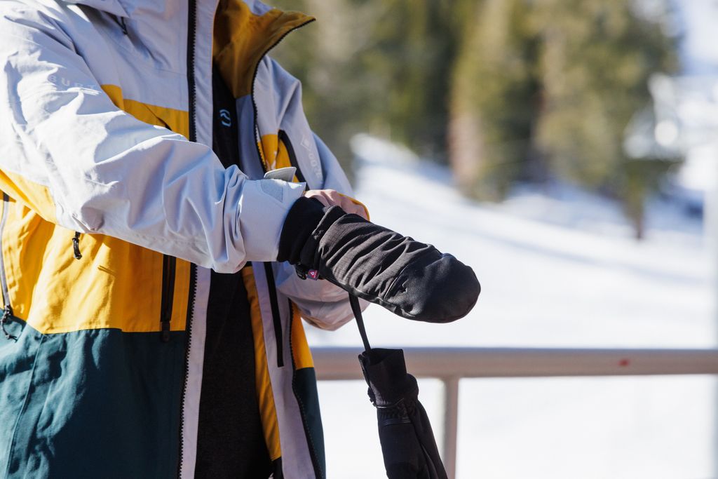 man pulling on snowboard mittens
