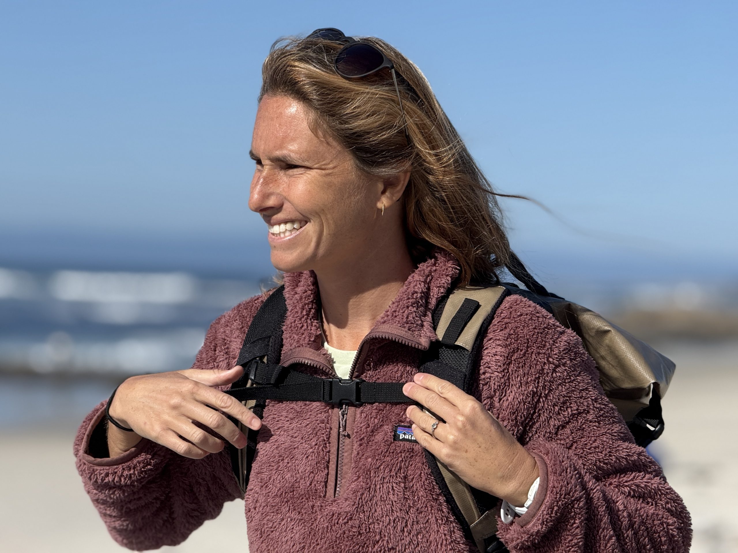 close up of a woman wearing a surf backpack