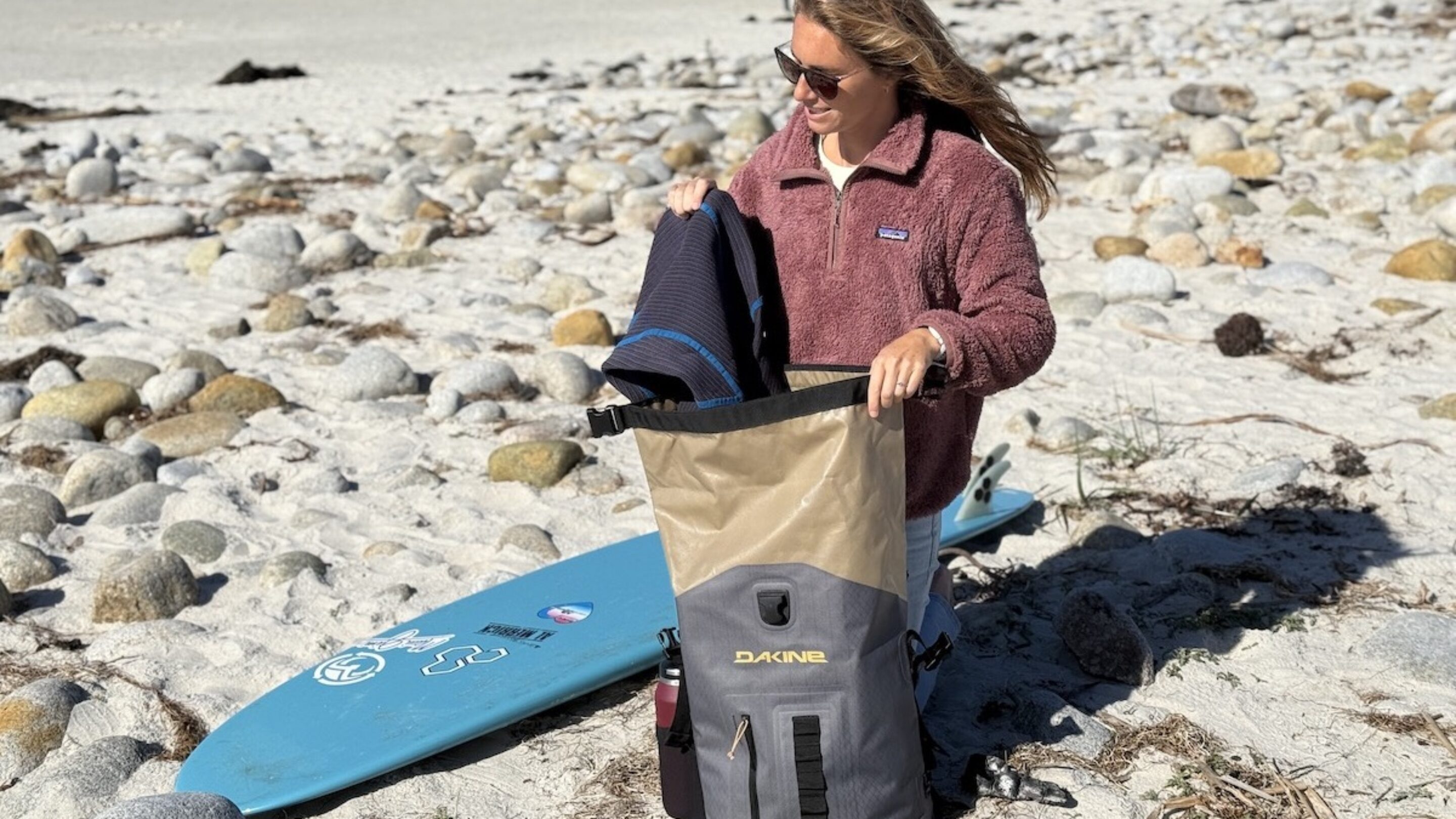 a woman at the beach with a Dakine Cyclone surf backpack