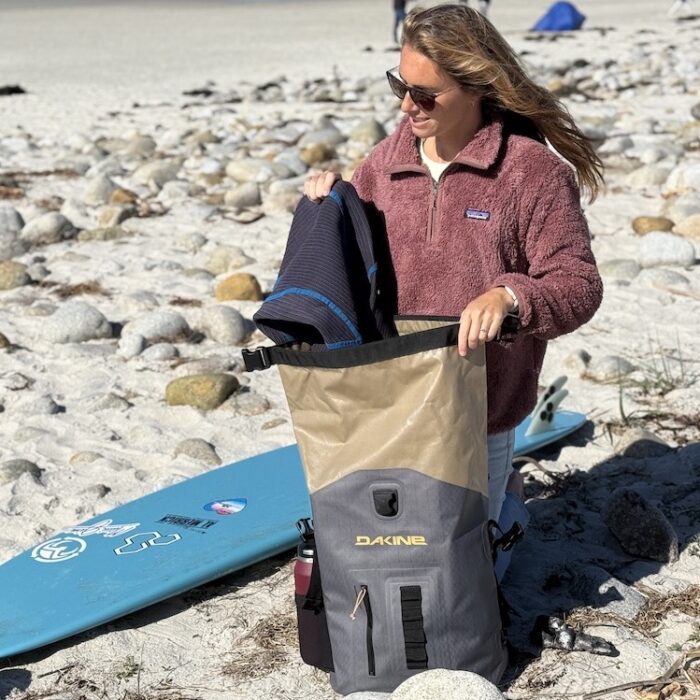 a woman at the beach with a Dakine Cyclone surf backpack