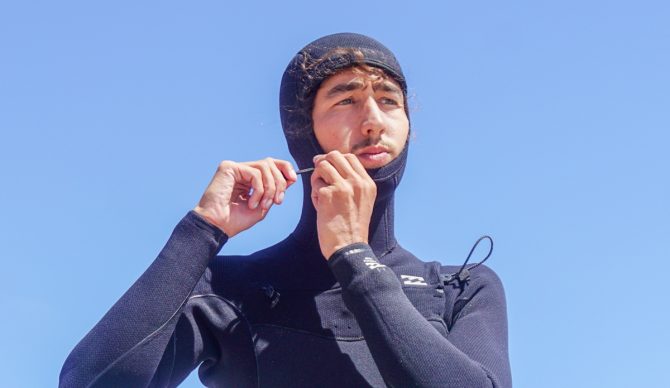 tightening the hood on the Billabong Furnace Natural wetsuit