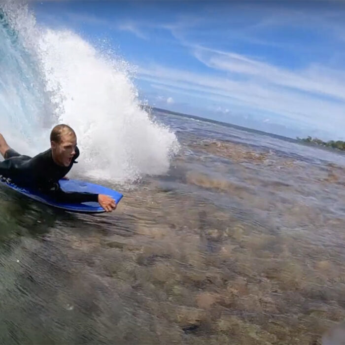 bodyboarders in Tahiti over dry reef
