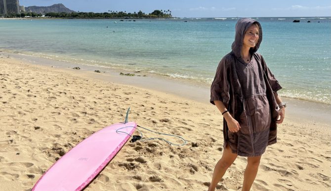 Rebecca in a surf poncho on the beach